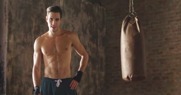 ボクシング バッグに立ってを親指を身振りで示す発汗のスポーツマンのスロー モーション ビデオ — ストック動画