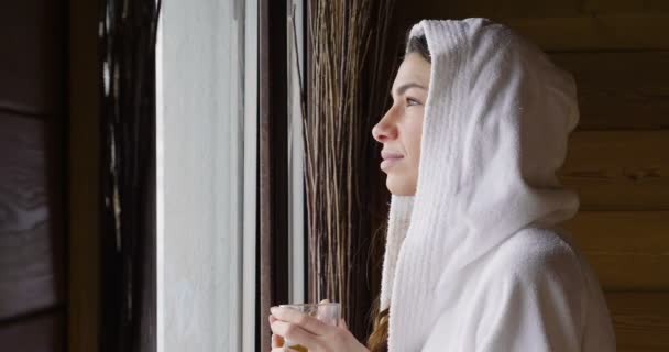 Una Hermosa Mujer Mira Por Ventana Con Albornoz Blanco Bebe — Vídeos de Stock