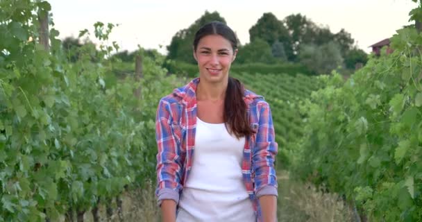 美しい女の子 の農家の葡萄畑を見て笑みを浮かべて麦わら帽子をかぶってシャツ ブラック ボードを保持します 概念の生態学 ワイン バイオ製品検査水天然物農業 — ストック動画
