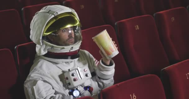 Astronauta Assiste Filme Cinema Enquanto Come Milho Pop Desfruta Dele — Vídeo de Stock