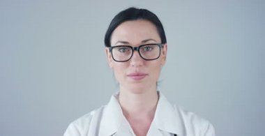 Beyaz önlük, stetoskop ve kameraya gülümseyen kadın doktor video 