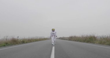 Bir astronot uzaydan yeni gezegende yeni dünyayı keşfetmeye ve orada yaşamak için bir yolun ortasından yürümek indi. Kavramı: başarı road, rüyalar, astronot, ilham.