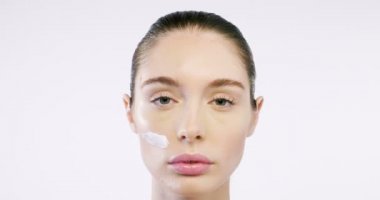 Kremler sayesinde mükemmel ciltli güzel bir kadının yüzünü kapatıyoruz. Yaşlanmayı önleyen kremler ve kırışık gözler sayesinde. Güzellik, temizlik ve mükemmellik kavramı.