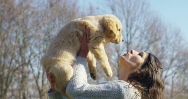 Kızı kucağına, oyun, öpüyor, onun köpek doğurmak golden retriever köpek yavrusu safkan ile trenler. Oyun ve mutlu ve gülümseme. Konsept: kukla, hayvanları, yumuşaklık ve doğa sevgisi.