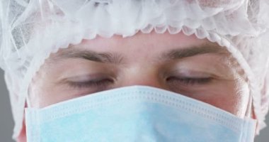 Bir doktor veya cerrah tıbbi maske, solunum, kahverengi gözleri, cerrahi bir delik, bir hastane ya da bir klinik portresi. Konsept: ilk tıbbi yardım, yardımcı tedavi insanlar, cerrahi, sağlık, doktorlar.