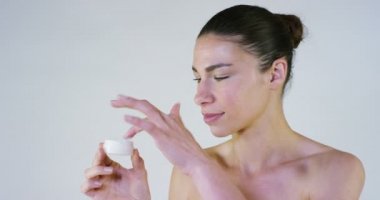 Güzel bir genç kız portresi krem üzerinde ihale bir vücut losyonları, yorgunluk ve ağrı, beyaz arka plan relieves. Konsept: biyolojik ürünler, spa prosedürler, taze, kendinizi mükemmel bir cilt, kişisel bakım, aşk