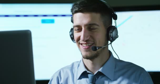 一名在客服或一些机场控制塔站工作的年轻人 日夜微笑着接听电话给顾客 — 图库视频影像