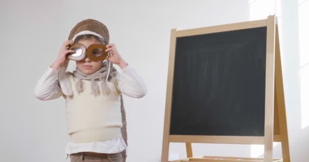 Vídeo Niña Vestida Piloto Pie Pizarra Con Gafas — Vídeo de stock