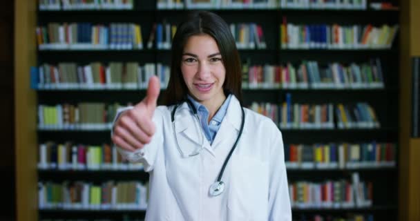 Young Beautiful Female Doctor Library Smiling Happy Holding Books Doing — Stock Video