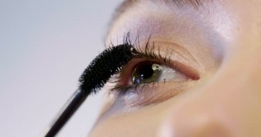 Bir kadın en iyi makyaj ve renk ve onun göz özellikleri vurgulamak için göze rimel koyar. Kavramı: makyaj, Güzellik, model.