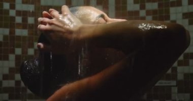 Güzel genç kız (kadın) bir mavi mayo içinde mavi bir arka plan üzerinde bir duş rahat. Konsept: spa prosedürler, vücut masajları, spa krem, sakin ol, spa su tedavileri, yüzme havuzu