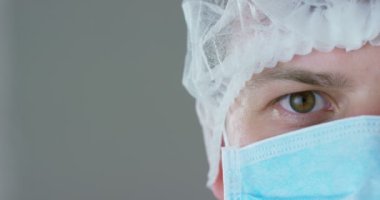 Bir doktor veya cerrah tıbbi maske, solunum, kahverengi gözleri, cerrahi bir delik, bir hastane ya da bir klinik portresi. Konsept: ilk tıbbi yardım, yardımcı tedavi insanlar, cerrahi, sağlık, doktorlar.