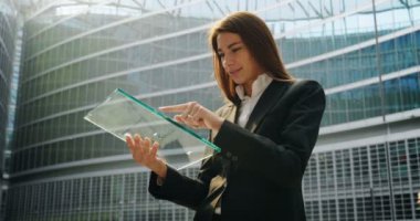 kullanarak ve şeffaf dijital tablet tarama ve bina, office cam adam hologram ayakta işkadını ağır çekim video