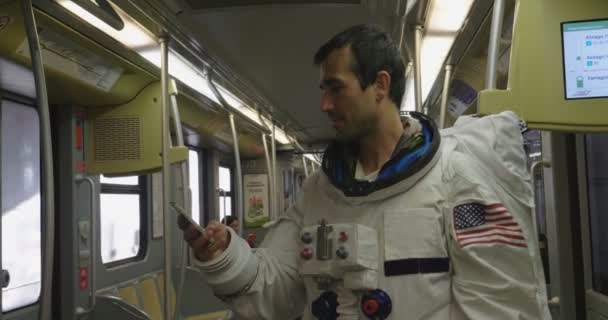 一个穿着宇航员服装的人使用智能手机来呼叫和发送消息 宇航员一边看着手中的电话 一边微笑 电话促销 信息和空间通话 — 图库视频影像
