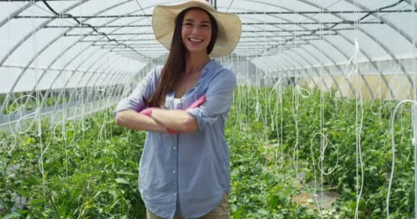 Krásná dívka v slaměný klobouk a nosí růžové gumové rukavice, práce s tabletem, ve skleníku. Koncepce: bio produkty, přírodní produkty, čerstvé, lahodné, ovoce, zeleniny, pěstování vodních rostlin