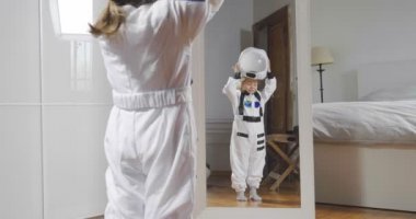 astronot bir ayna önünde bir kask giymiş küçük bir kız portresi kılığında