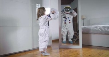 Bir çocuk astronotun takım elbise aynanın önünde görünüyor ve büyük, onun geleceği, işini, hırsı büyümeye görünüyor. Kavramı: gelecek, Aile, hırs, astronotun çalışma
