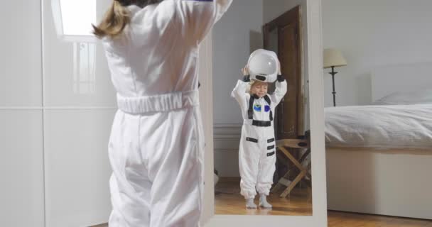 Porträt Eines Kleinen Mädchens Astronautenkleidung Mit Helm Vor Einem Spiegel — Stockvideo