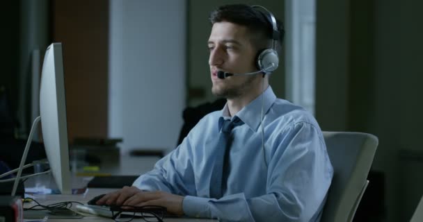 カスタマー サービスまたはいくつかの空港の管制塔駅で動作 若い男の昼と夜電話笑顔で顧客に呼び出しに応答します — ストック動画