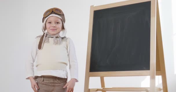 Film Dziewczynka Przebrana Pilota Stoi Tablica Ramionami Skrzyżowanymi Uśmiechając Się — Wideo stockowe