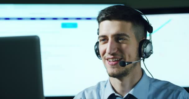 一名在客服或一些机场控制塔站工作的年轻人 日夜微笑着接听电话给顾客 — 图库视频影像