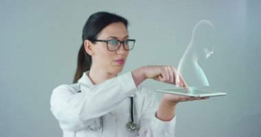 Bir doktor, cerrah, bir teknolojik inceliyor dijital holografik plaka temsil hastanın vücut, kalp akciğer, kaslar, kemikler. Konsept: Futuristik tıp, insan vücudu ve gelecek.