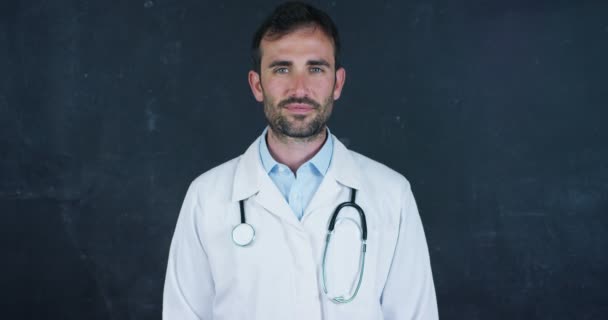 ホワイトラボコートと聴診器を身に着けているプロの医者の男のビデオ ジェスチャ親指とカメラで笑顔 — ストック動画