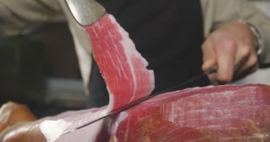 Makro bir dilim jambon, mükemmel kalitede, geleneğe göre bıçakla kesen bir şefin kapatın. Kavramı: jambon, gıda, İspanya ve İtalya, yemek tedarik.