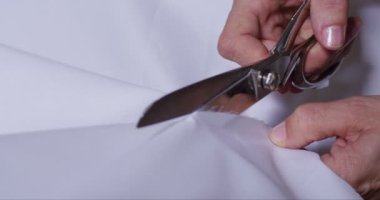 Orta yaş kadın el bir masa üzerinde beyaz Kumaş kesme makası ile süper ağır çekim