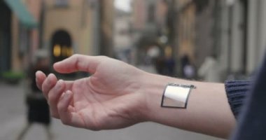 adam kısmi görünümü, elinde mikroçip ile adam kırpılmış video, yürüyen insanlar ile bulanık arka plan