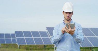 holding ve dijital tablet gezinme ve açık havada güneş panelleri sistem qurğu çalışma kask içinde adam video 
