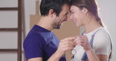 Portre aşık bir çiftin yere oturmuş ve onlar sadece bir ev satın aldı ve hareket ediyor. Gelin ve damat gülümse ve ellerinde yeni ev tuşlarını basılı tutun. Kavramı: gelecek, Aile.