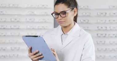 ağır çekim optik mağazasında gözlüklü ve dijital tablet tarama optik merkezi içinde kadın 