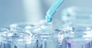 Bir laboratuarda, pipetli bir bilim adamı test tüplerindeki DNA ve molekülleri ayırmak için renkli bir sıvıyı analiz eder. Konsept: araştırma, biyokimya, doğa, ilaç