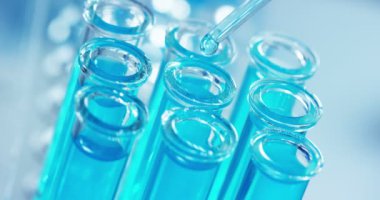 Bir laboratuarda, pipetli bir bilim adamı test tüplerindeki DNA ve molekülleri ayırmak için renkli bir sıvıyı analiz eder. Konsept: araştırma, biyokimya, doğa, ilaç