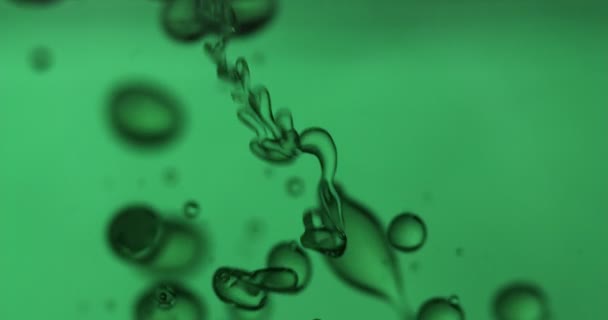 particules de vitamines ou d'autres particules flottantes dans le liquide au ralenti tandis que les vitamines sont mélangées les unes aux autres et se réunissent pour créer une recette pour une peau saine 