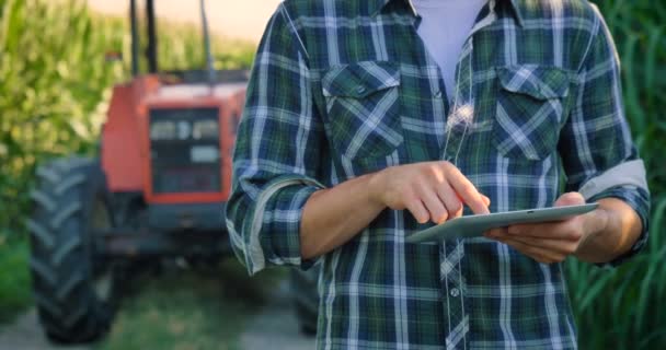农民在玉米种植园使用数字平板电脑的拖拉机的慢动作视频 — 图库视频影像