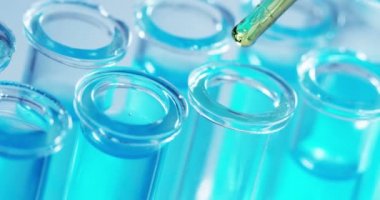 Bir laboratuarda, pipetli bir bilim adamı test tüplerindeki DNA ve molekülleri ayırmak için renkli bir sıvıyı analiz eder. Konsept: araştırma, biyokimya, doğa, ilaç