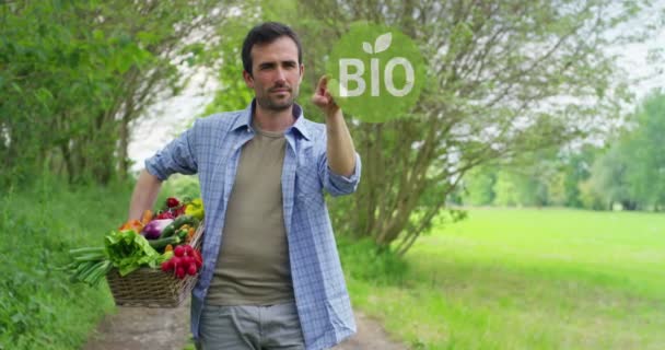 Video eines gutaussehenden Bauern auf dem Land, der einen Korb mit Erntegemüse und anrührendem Hologramm hält 