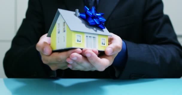 pronajmout nebo koupit dům .the rukou pojistitele nebo realitní agent ukazuje dům s klíče od domu .