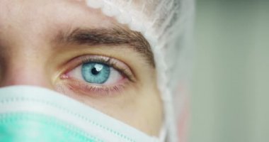 tıbbi maske takan doktor adam yüz kırpılmış video, kameraya bakarak 