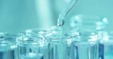 Bir laboratuarda, pipetli bir bilim adamı test tüplerindeki DNA ve molekülleri ayırmak için renkli bir sıvıyı analiz eder. Konsept: araştırma, biyokimya, doğa, ilaç