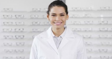ağır çekim video kameraya bakarak ve gülümseyen optik merkezi salonu içinde esmer beyaz kadın 
