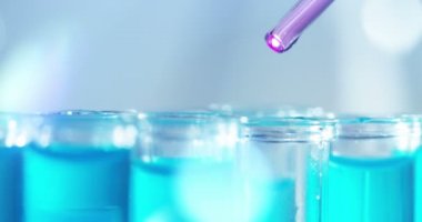 Bir laboratuarda, pipetli bir bilim adamı test tüplerindeki DNA ve molekülleri ayırmak için renkli bir sıvıyı analiz eder. Konsept: araştırma, biyokimya, doğa, ilaç