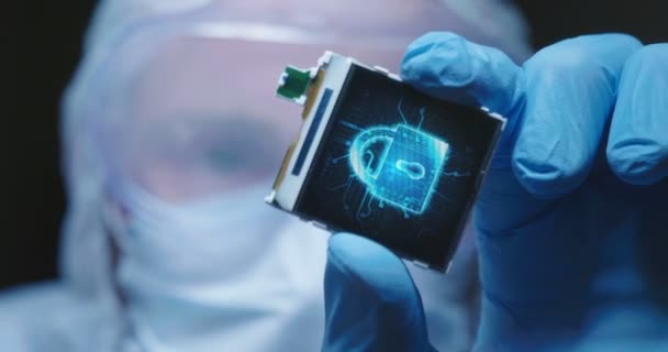 超现代电子制造工厂设计工程师无菌整体持有微芯片与符号在未来主义全息 — 图库视频影像