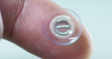 Makro çekim bir kontakt lens teknolojisi ile gözleri ve artış diyoptriden daha iyi görmek için küçük parça tutan bir parmak. Konsept: göz muayenesinde, optik, üstün teknoloji