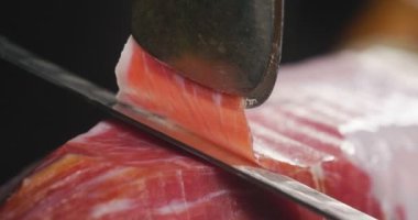 Makro bir dilim jambon, mükemmel kalitede, geleneğe göre bıçakla kesen bir şefin kapatın. Kavramı: jambon, gıda, İspanya ve İtalya, yemek tedarik.