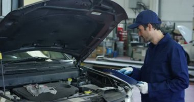 Araba servisinde uzman tamirci. Arabayı, motoru, karbüratörü kontrol ediyor. Konsept: makinelerin onarımı, hatalı tanı, onarım uzmanı, teknik bakım ve gemideki bilgisayar.