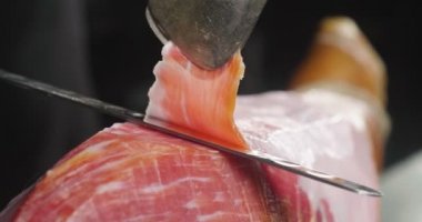 Makro bir dilim jambon, mükemmel kalitede, geleneğe göre bıçakla kesen bir şefin kapatın. Kavramı: jambon, gıda, İspanya ve İtalya, yemek tedarik.