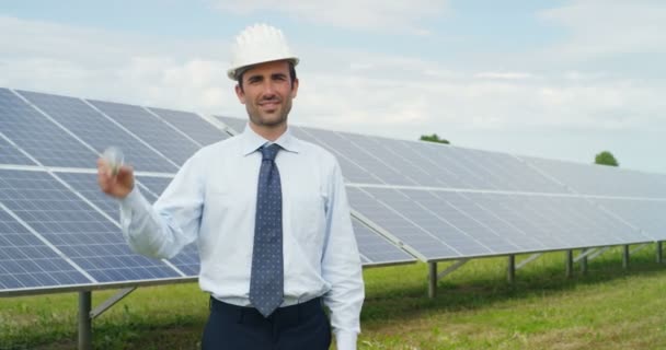 カメラ電球表示と Eco ソーラー パネル 屋根のセル太陽電池システム駅に立っている男のスロー モーション ビデオ — ストック動画